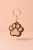 hermony_a_golden_keyring_with_several_small_chain_links_is_posi_2be6cafa-010b-431a-8f18-ddcf3188dcbe.png